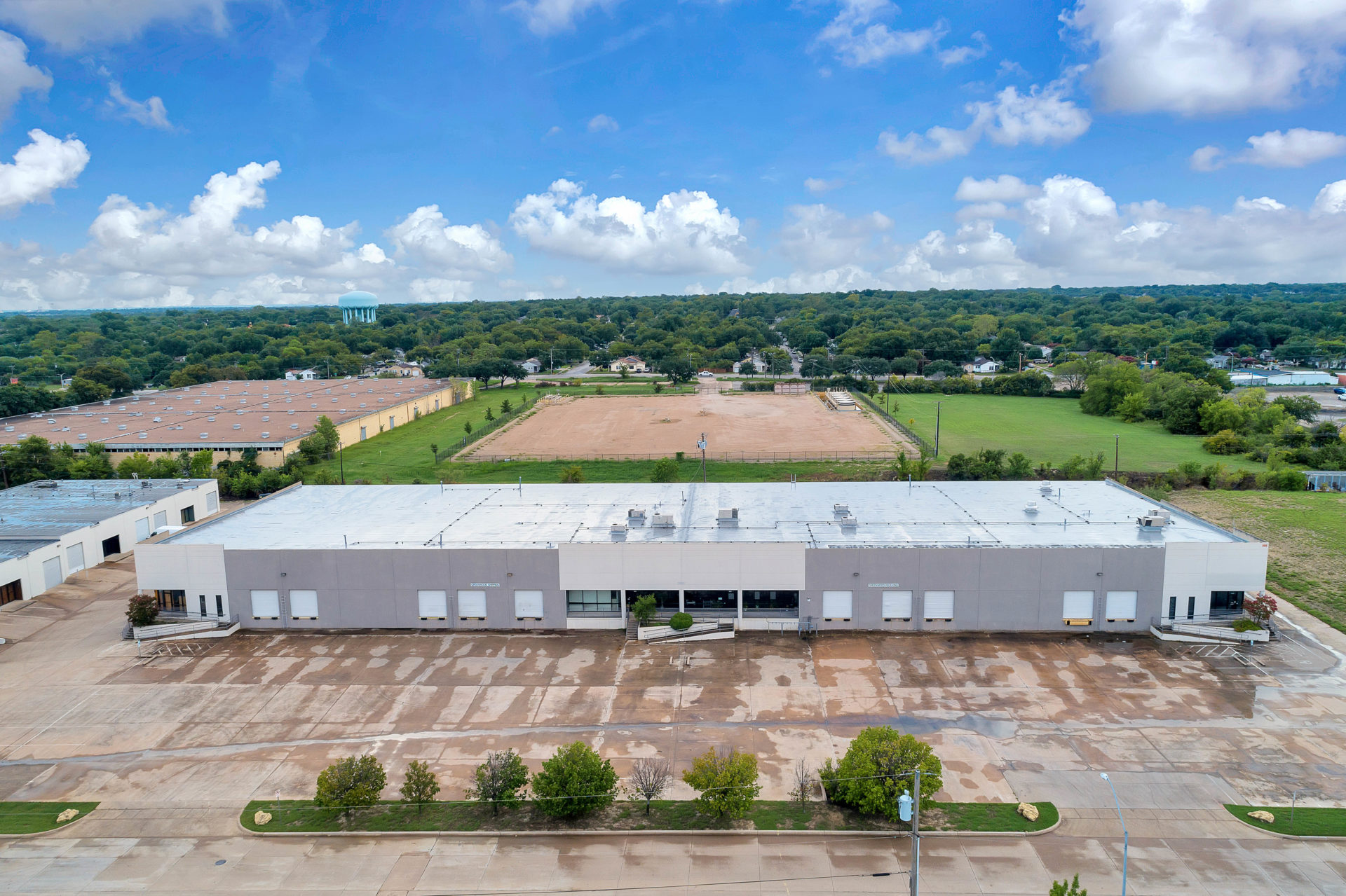 Aerial view of one building in the Suffolk Business Park with grey and white siding, entrance ramps, and loading docks