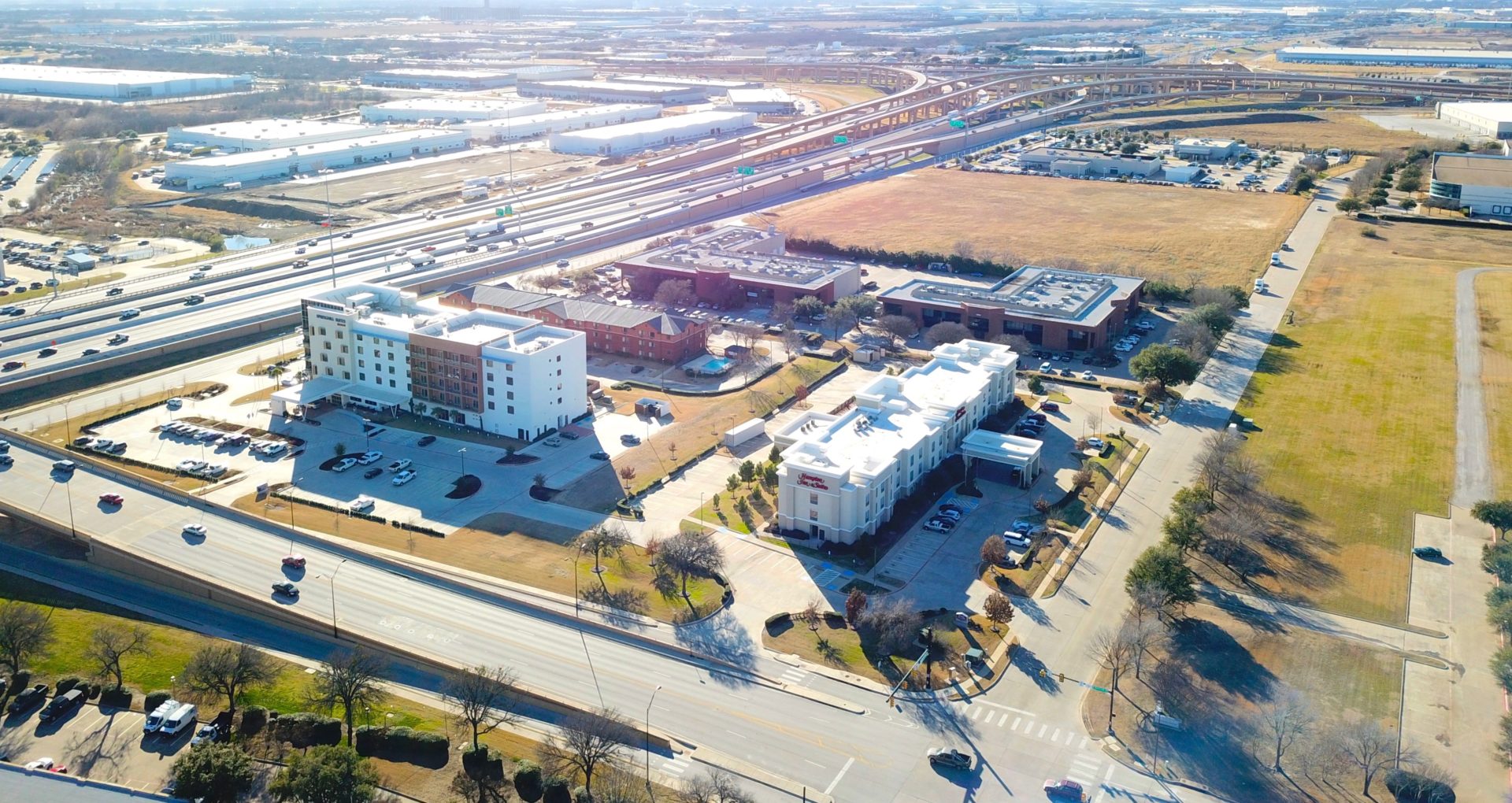 Aerial view of the two Fossil Creek Place buildings with the surrounding parking lots and hotels and adjacent highways